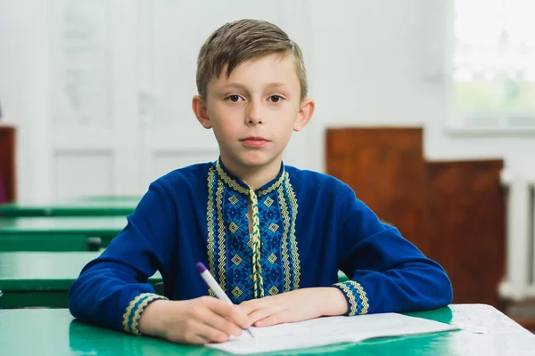 青い刺繍の伝統的なウクライナのシャツの少年の肖像画 彼の手にペンを保持少年 2020 — ストック写真