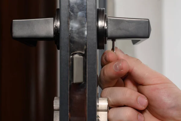 Hex key and installation of door lock and handle, close-up installation work, interior door.
