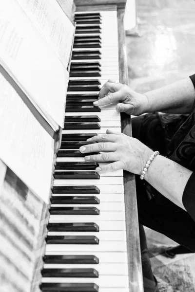 ピアノと手をクローズアップ 黒と白の写真 結婚式の終わり お祝いの夜の楽器 — ストック写真