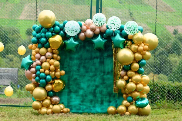 Green background photo zone with green and yellow balloons.