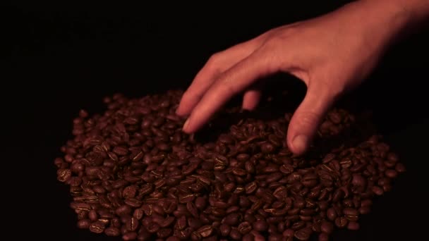 男はコーヒー豆を手で注ぎます スローモーションと黒の背景 Hdビデオとコピースペース — ストック動画