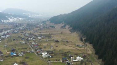 Ukrayna 'daki bir Karpatlar köyünün en üst görüntüsü, ilkbaharın başlarında dağlarda, 4k drone videosu.