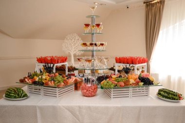 Yemek, içecek, et ve sebze tabakları olan şenlik masası..