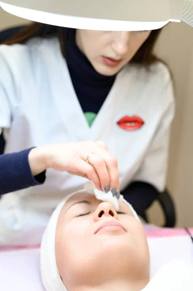 Procedure at a cosmetologist, cleansing the face of cosmetics and preparing the face for massage, close-up procedure.