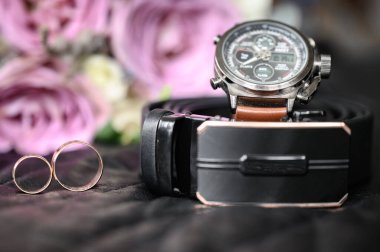 Saatli kemer, alyans ve bir buket çiçek, damadın sabahki kompozisyonu, adamın düğün dekoru..