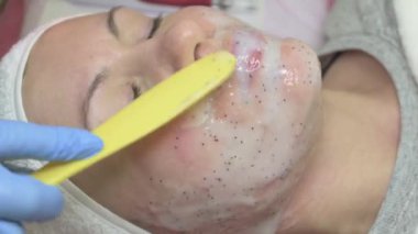 A clients visit to a cosmetologist, moisturizing the face with a cosmetology mask, applying a mask to the face, video 4k.