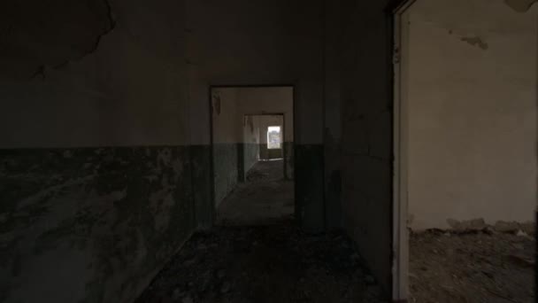 壊れたドアの道と破壊された壁の塗料 放棄された工業ビルの暗い廊下 ビデオ4K — ストック動画