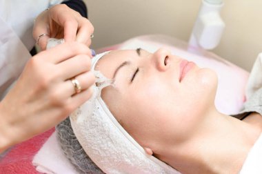 Removing a moisturizing mask from the face in a cosmetology office, cosmetology procedures in a spa salon.