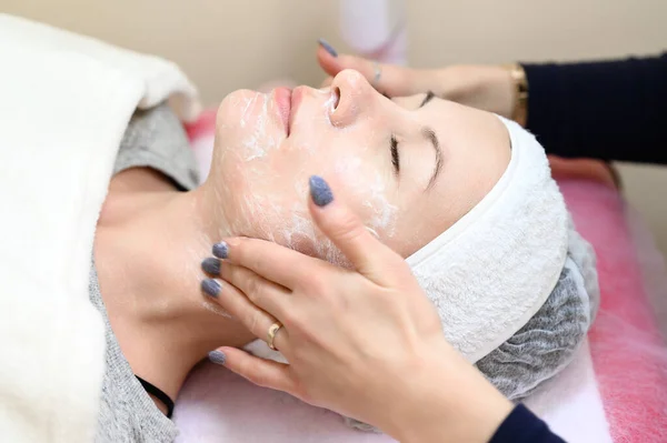 Procedure at a cosmetologist, cleansing the face of cosmetics and preparing the face for massage, close-up procedure.
