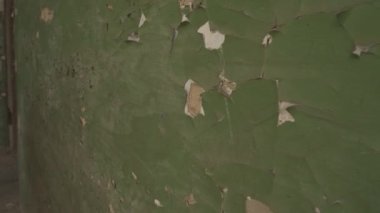 Old wall with damaged paint, weathered wall with green paint, damaged wall texture and 4k video.
