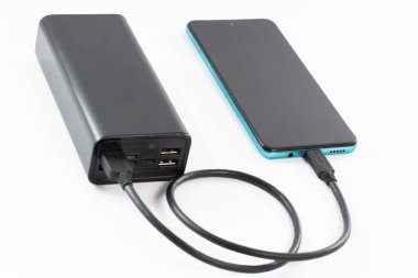 Kablolu ve telefonlu güç bankası, kopyalama alanı ve beyaz arkaplan, izole güç bankası ve telefon.