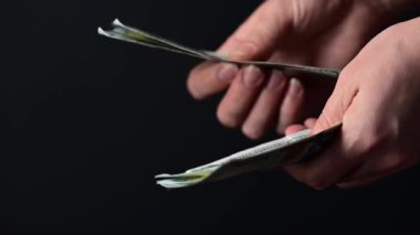 Yüz dolarlık banknotların dönüştürülmesi, iş adamlarının para sayması, kara arka planda para, dünya piyasası para birimi.