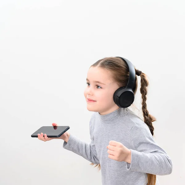 Happy Little Girl Wireless Headphones Phone Portrait Girl Pigtails White — Zdjęcie stockowe