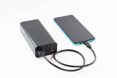 Kablolu ve telefonlu güç bankası, kopyalama alanı ve beyaz arkaplan, izole güç bankası ve telefon.