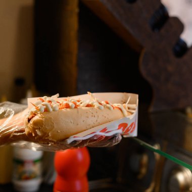 Bir sosisli sandviç yapma süreci, bir işçi müşterinin siparişini yerine getirir ve bir sosisli sandviç, bir fast food restoranı hazırlar..