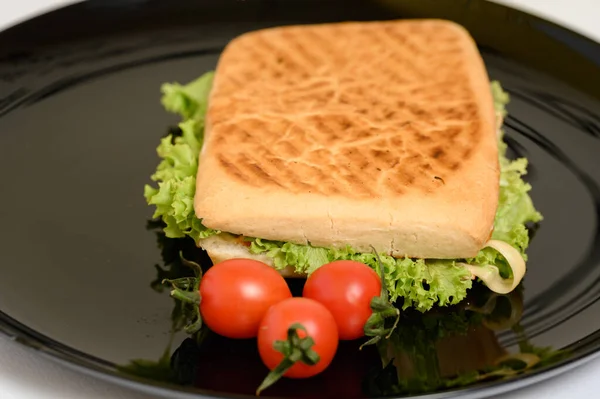 用绿色生菜和樱桃西红柿在黑盘上做菜 是一种快捷可口的小吃 — 图库照片