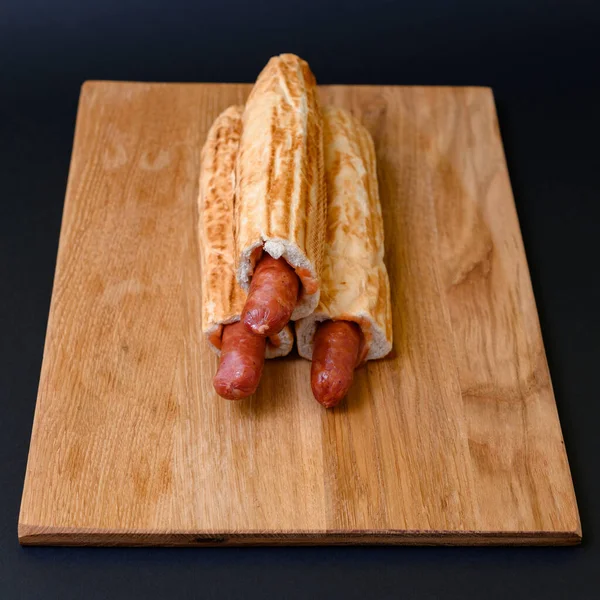 Drei Französische Hot Dogs Auf Einem Holzbrett Auf Schwarzem Hintergrund — Stockfoto