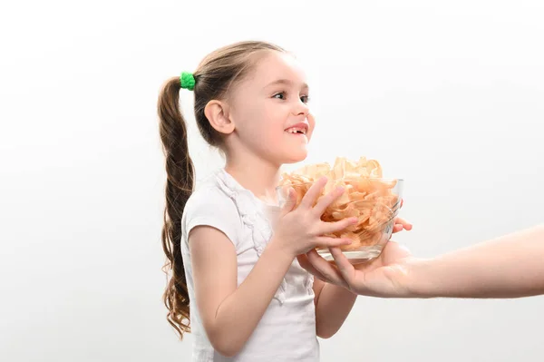 小女孩得到了一大碗薯片零食 里面有猪油 一个吃薯片的小女孩的白色背景画像 一个小孩和不健康的快餐 — 图库照片