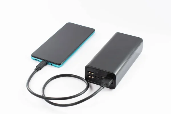 power bank with charging cable and phone, copy space and white background, isolated power bank and phone.