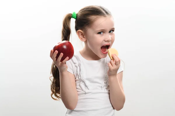 红苹果和薯片 儿童健康和不健康的食物 小女孩在健康和不健康之间做出选择 白色背景的儿童肖像和复制空间 — 图库照片