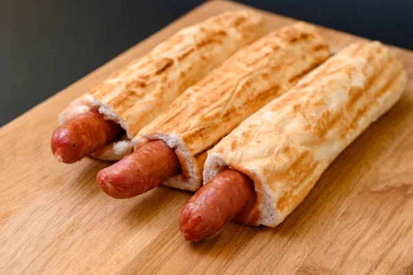 Drei Französische Hot Dogs Auf Einem Holzbrett Auf Schwarzem Hintergrund — Stockfoto