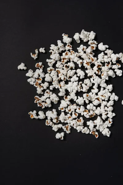 fried popcorn on black background close-up, ready-to-eat food, corn cooking method, copy space and black background with popcorn.