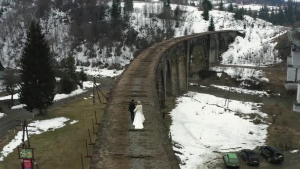 ヴォロフタ ウクライナ2021年3月31日 花嫁と新郎は 市内の古い橋に沿って歩く ヴィオダクト橋と花嫁のカップル ビデオ4K — ストック動画