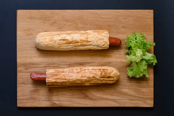 Zwei Französische Hot Dogs Auf Einem Holzbrett Auf Schwarzem Hintergrund — Stockfoto