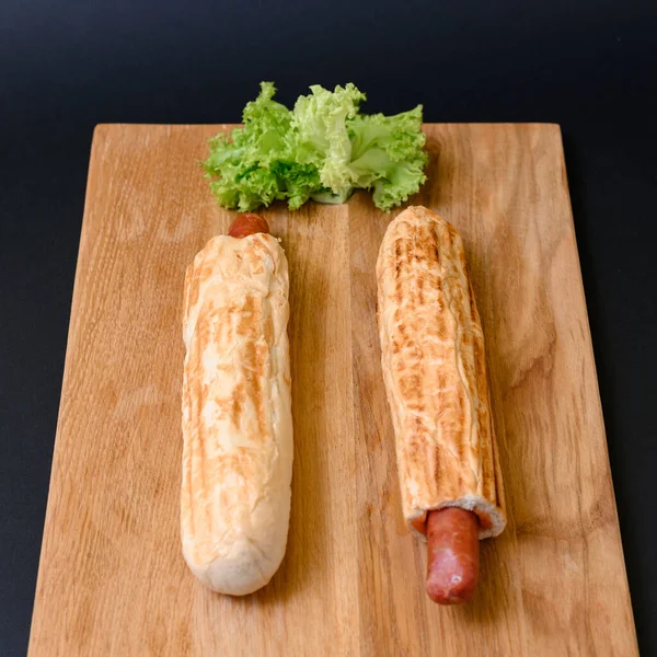Zwei Französische Hot Dogs Auf Einem Holzbrett Auf Schwarzem Hintergrund — Stockfoto