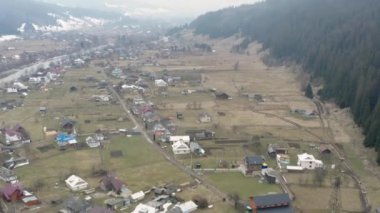 Ukrayna 'daki bir Karpatlar köyünün en üst görüntüsü, ilkbaharın başlarında dağlarda, 4k drone videosu.