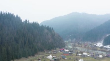Ukrayna 'daki bir Karpatlar köyünün en üst görüntüsü, ilkbaharın başlarında dağlarda, 4k drone videosu.