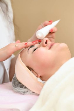 Spa salonundaki yüzüne krem sürüyorum. Güzellik salonundaki kız..