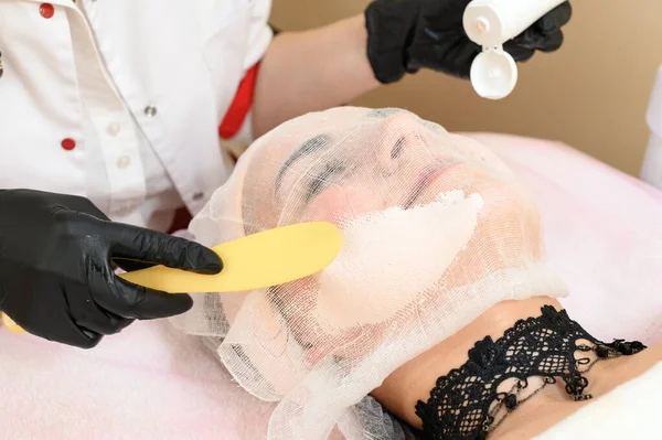 Beautician Uses Spatula Apply Cream Already Prepared Face Gauze Procedure — Stock Photo, Image