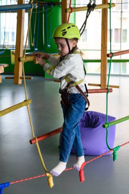 Çocuğun aktif ve fiziksel gelişimi, kız oyun odasındaki kablodan geçer..