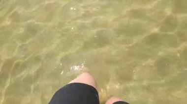 Suda ayaklar, temiz su ve deniz kenarında temiz kum, suda yürüyen kadın..