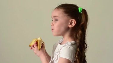 Mutlu küçük kız muz, meyve ve bebek, sağlıklı ve diyet yiyecekler yer..