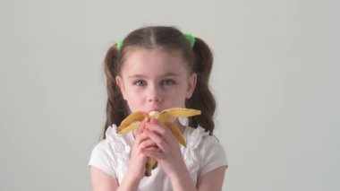 Mutlu küçük kız muz, meyve ve bebek, sağlıklı ve diyet yiyecekler yer..