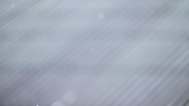雪片のスローモーション 村の冬 窓からの雪の眺め ぼやけた動きとボケ — ストック動画