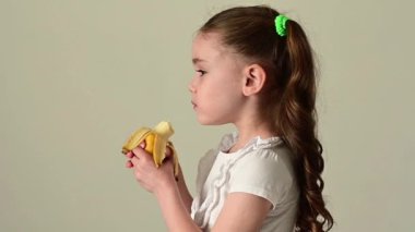 Mutlu küçük kız muz, meyve ve bebek, sağlıklı ve diyet yiyecekler yer..