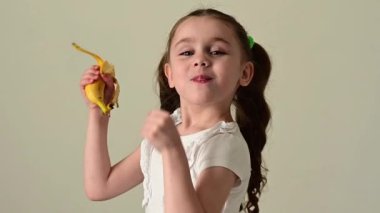 Mutlu küçük kız muz, meyve ve bebek, sağlıklı ve diyet yiyecekler yer..