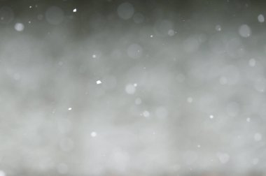 Falling snowflakes on night sky background, isolated for post production and overlay in graphic editor. Bokeh of white snow on a square shape gray background.