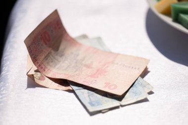 Ukrayna hrivniaları Ukrayna ulusal para birimi olan beyaz masa örtüsüyle kaplı bir masanın üzerinde yatar..