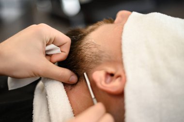 Bir berber, sakallı bir müşterinin boynunu tehlikeli bir jiletle tıraş eder. Sakalın hatlarını doğru şekil için traş ediyorum..