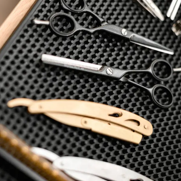 Barbers tools for mens haircuts laid out on a table close up. Set of scissors for haircuts.