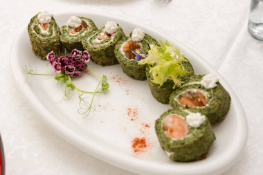 Peynir dolgulu ıspanak rulosu. Masada servis ediliyor. Beslenme atıştırmalığı..