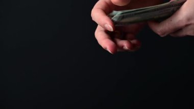 Yüz dolarlık banknotların dönüştürülmesi, iş adamlarının para sayması, kara arka planda para, dünya piyasası para birimi.