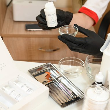 Ivano-Frankivsk, Ukrayna, 17 Mayıs 2023: Bir kozmetik uzmanı elinde bir karbonterapi maddesiyle kozmetik maddesini elinde tutuyor..