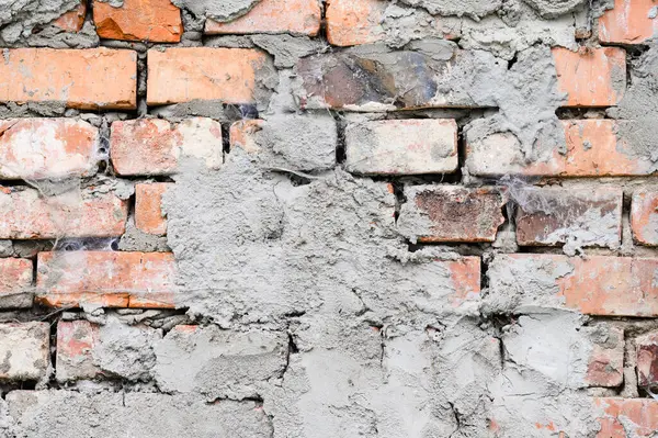 The background of the old wall is made of brown bricks, laid out from a cement sand mortar