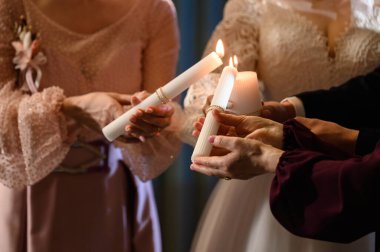 Gelin ve damat ellerinde yanan mumlar, düğün gelenekleri.