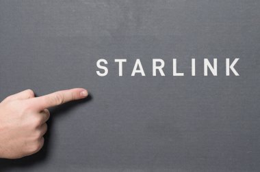 Ivano-Frankivsk, Ukrayna 2 Aralık 2023: Logolu Starlink anten kutusu, işaret parmağıyla Space X şirketinin logosunu gösteren adam, uydu iletişim anteni.